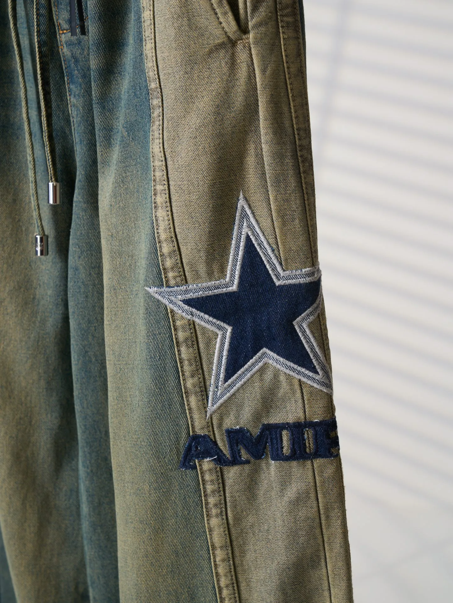 [Real auction] AMIRI/Emile five-pointed star logo embroidered jeans [In Stock] S M L XL Customized secret soft high-density denim, soft and waxy drape, skin-friendly and delicate, charcoal-tone mossy green washed background, replica Retro American texture, showing sophisticated and restrained street elegance. The structural tailoring on the side of the pants is neat and crisp. The high-definition embroidery on both sides is symmetrically laid out. The star emblem totem and the AMIRI letters complement each other. Perfectly blending retro accents with high-street luxury. The details are noble and the aura is self-contained. Imported machine embroidery technology is used. Advanced computer control systems and precision mechanical components are used to realize the five-pointed star and AMIRI logo embroidery operations. High precision. The lines are smooth and delicate. Priority is given to customizing 1:1 original denim materials to stir-fry snowballs and salt. Specially prepare the corresponding solution. Add a certain amount of dye, soak the denim materials in it to absorb the solvent, then scrub and dry to further fade and oxidize. Combination of rubbing and wrinkling whisker technology and gun painting whisker technology. Prioritize manual rubbing in specific areas to achieve a natural wrinkle effect. Then use specific tools to draw a whisker-shaped texture. The visual effect is full. Stone grinding light fermentation ➕ pulling, bleaching and softening. Through the mutual friction between pumice and clothing, the surface of the denim will produce wear and fading effects. By combining pulling and bleaching, the clothing will produce a certain texture and stretching effect while bleaching, and a loose fit.