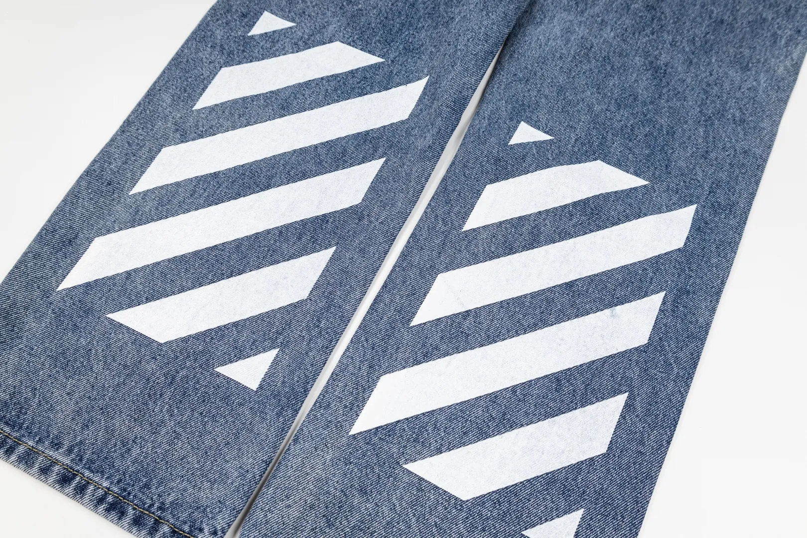 OFF-White 26 Autumn New Arrival Blue Pants White Printed Jeans This style uses 13.5 ounces of Japanese Kaihara custom-made soft structure denim, which is "stress-relieved" through a washing process on a selvedge weave base. The surface of the fabric has a slightly raised "peach skin" feel, just like a vintage item that has been worn for several years. It is skin-friendly but has clear muscles. The special double-twisting method of warp and weft allows the trouser legs to have an exaggerated volume (Extra Volume) and at the same time, the gravity is concentrated on the hem. When standing, it looks like mountains, and when walking, it creates flowing shadows. Style number: 2018# Color: Blue Size: 30 32 34 36